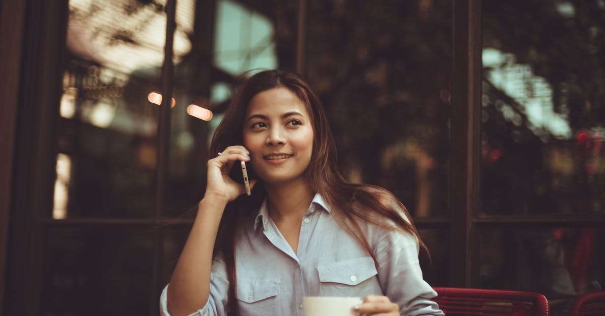 Portrait of Young Woman Using Mobile Phone in Cafe