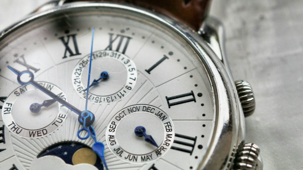 Detailed macro shot of an antique analog wristwatch with Roman numerals and calendar face.